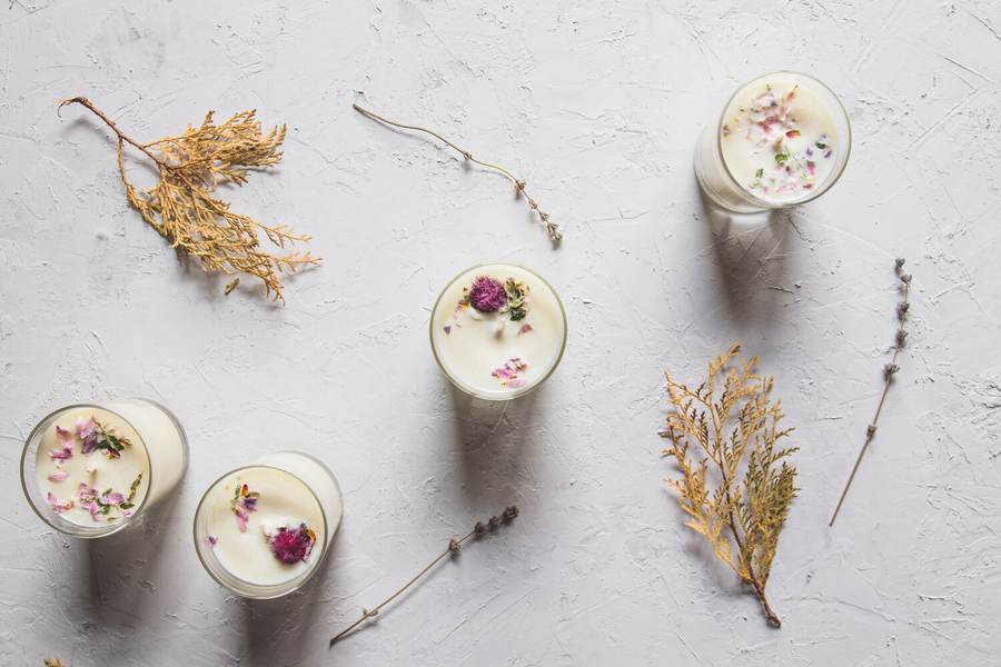 Poured candles and dried flowers on a pale surface