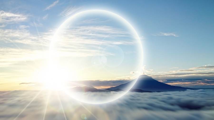 A ring of light breaking over a sea of cloud at dawn