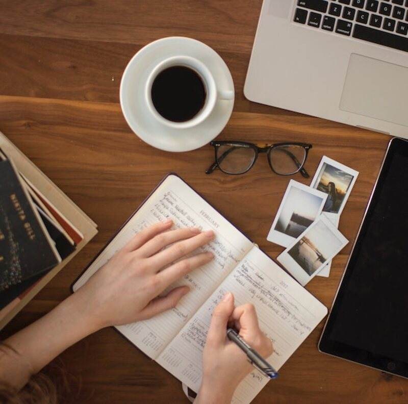 A journal and pen on a wooden desk