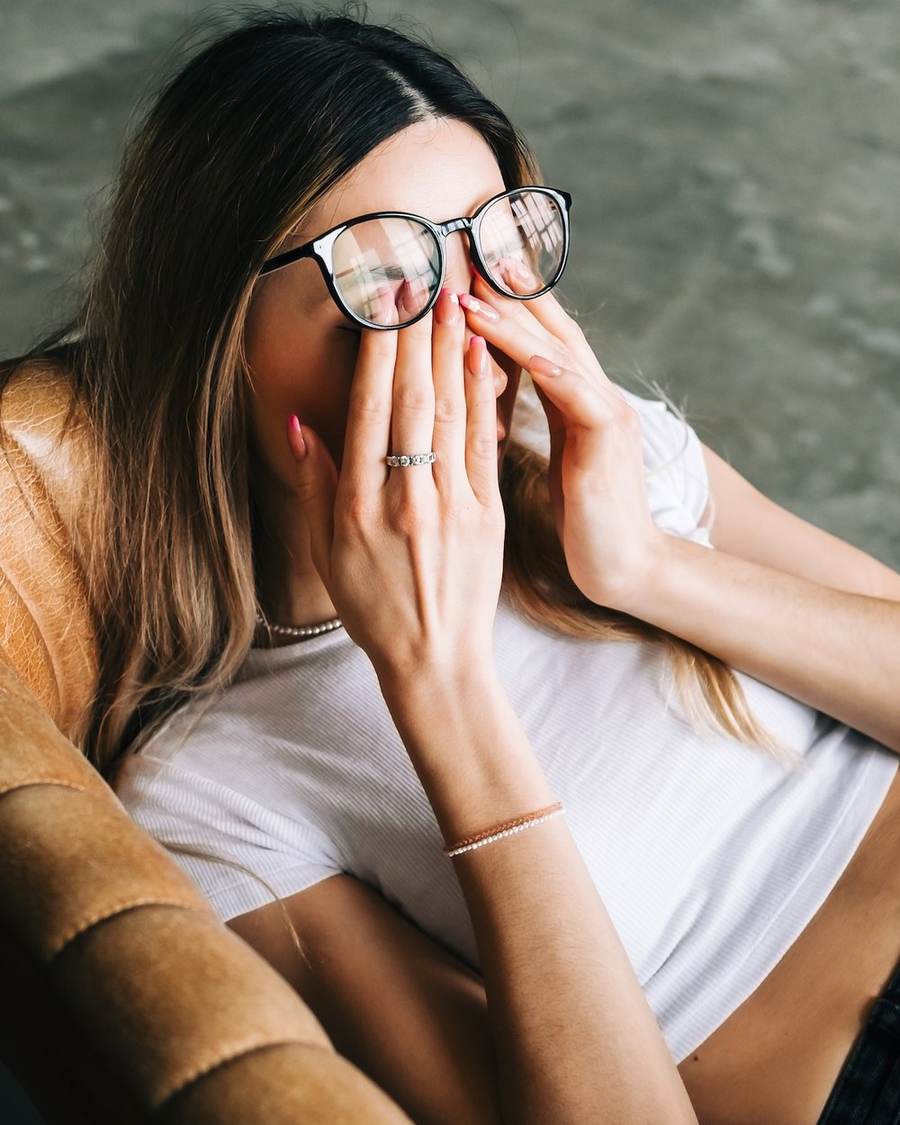 A woman sitting alone with her hands over her face